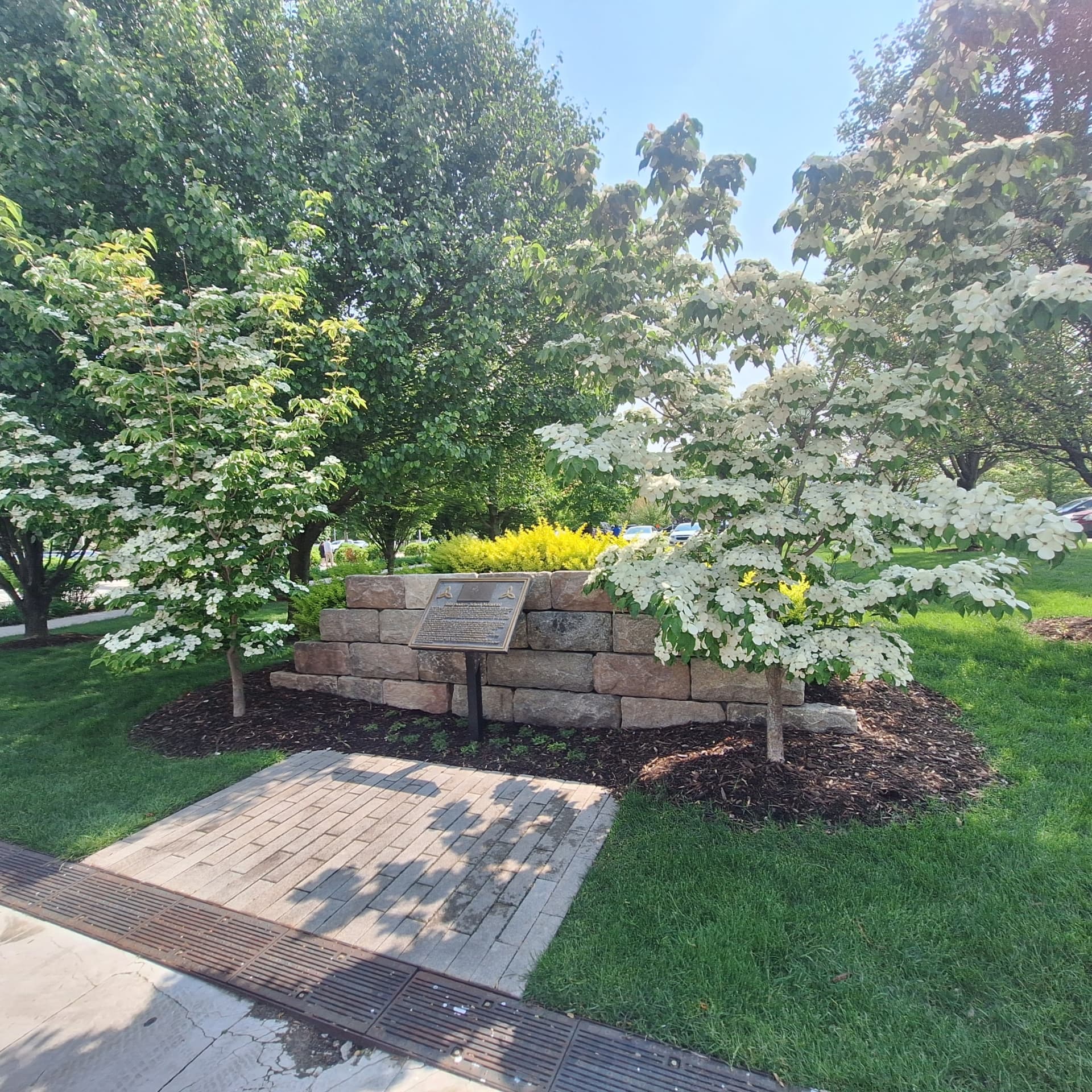 Boulder wall, paver patio and flowering trees in a memorial garden